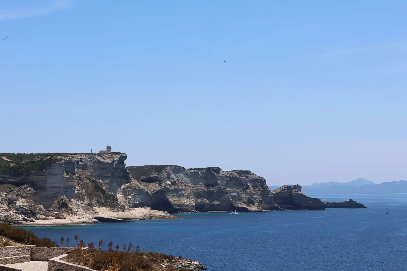 Falaises calcaires de Corse surplombant la mer Méditerranée sous un ciel dégagé