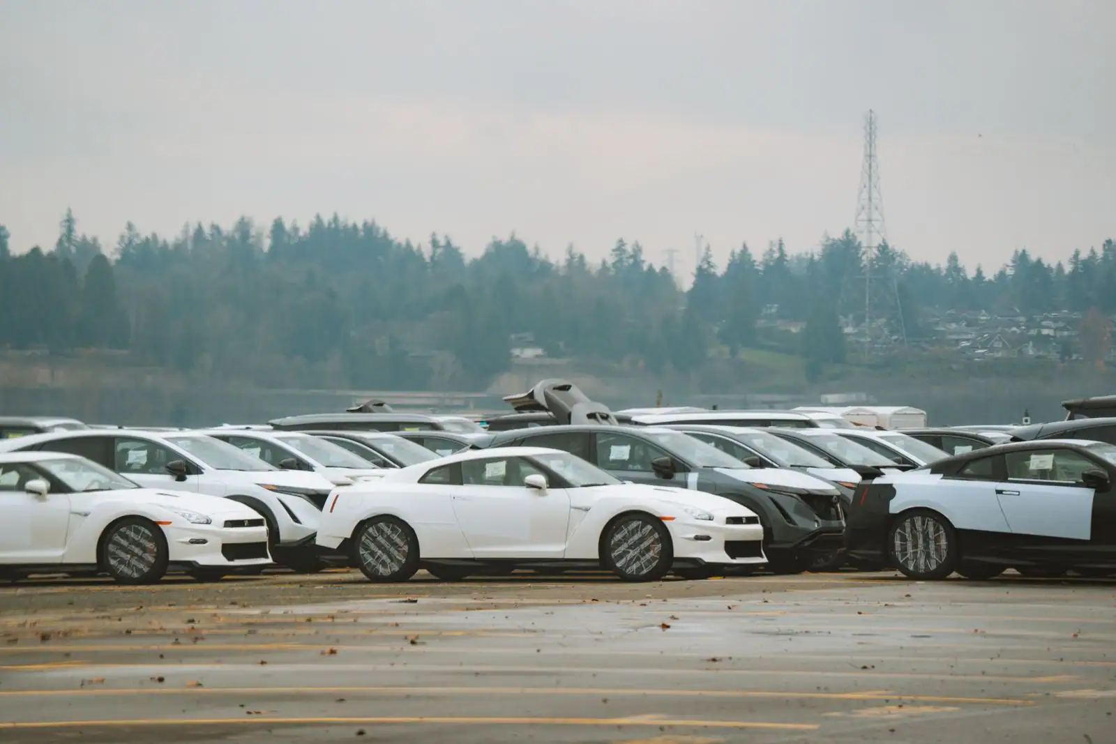Nombreuses voitures alignées en extérieur sur un vaste parking, image illustrant le secteur automobile.
