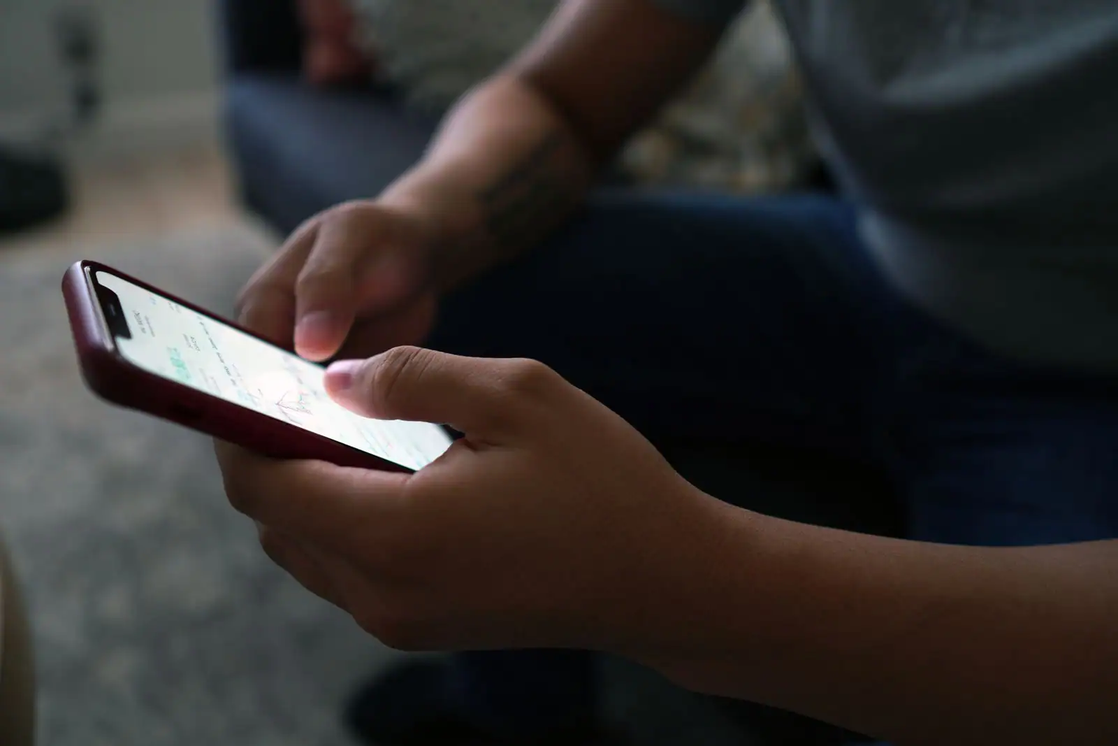 Personne consultant l'actualité sur l'écran de son smartphone tenu à deux mains