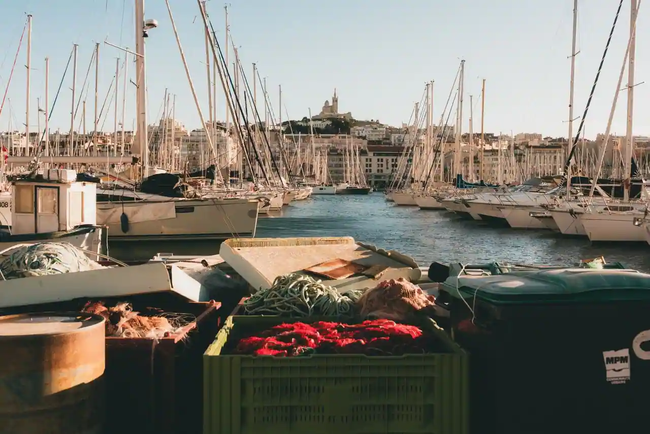 Voiliers amarrés dans le Vieux-Port de Marseille, Notre-Dame de la Garde sur la colline en arrière-plan.
