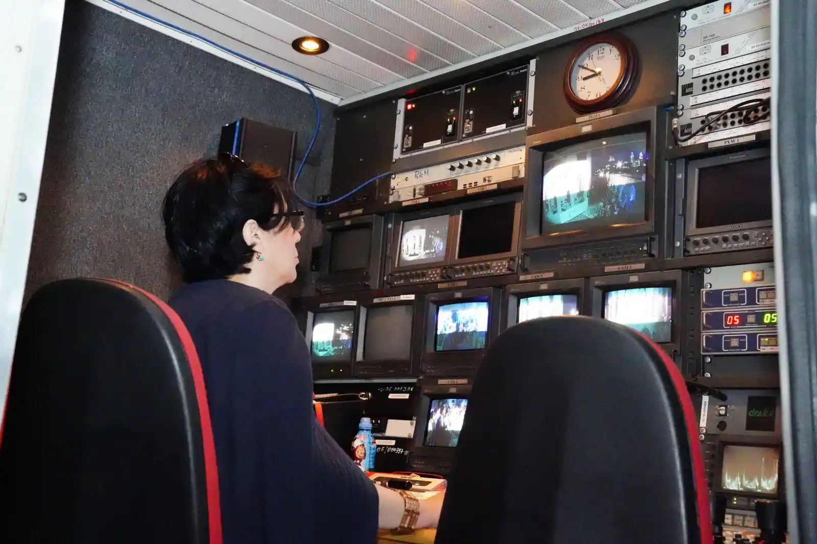 Régie de diffusion télévisée, un technicien face à un mur d'écrans de contrôle