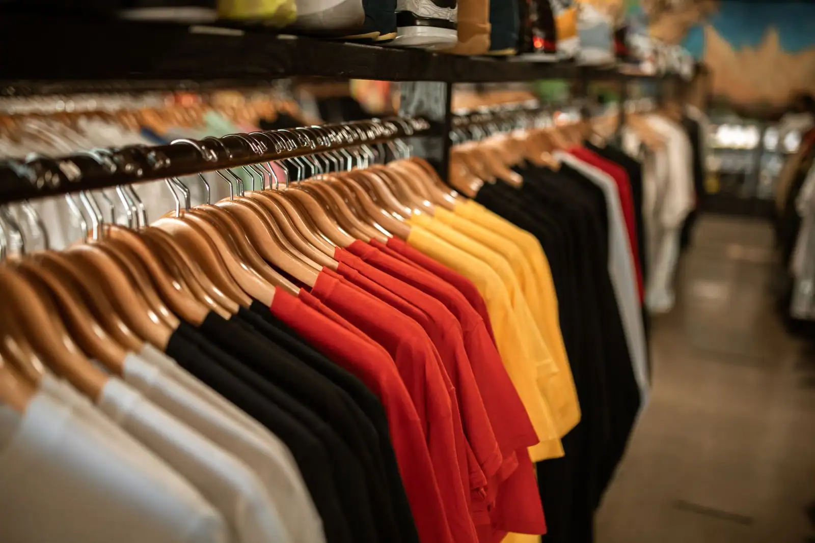 Portants de vêtements colorés suspendus sur des cintres, prêts pour la vente