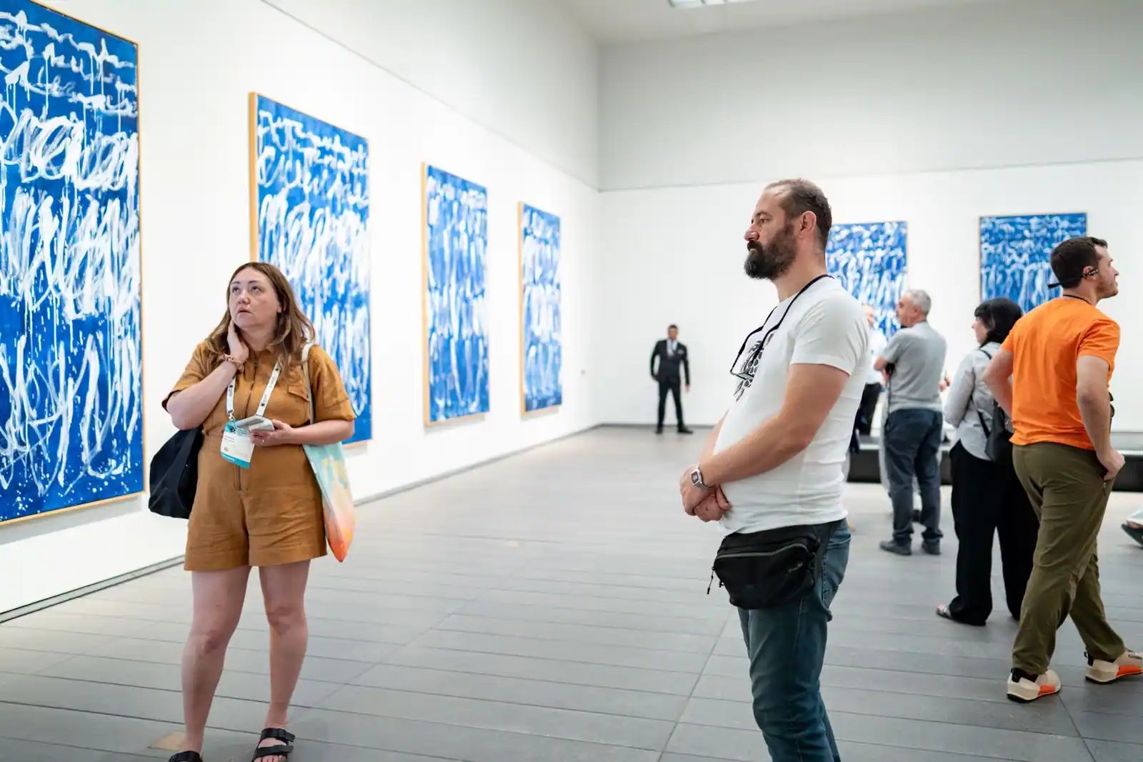 Intérieur d'un musée d'art contemporain, vaste galerie d'exposition épurée avec des visiteurs.