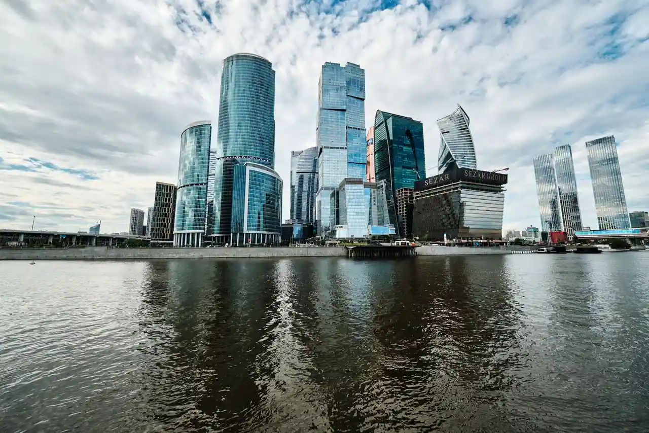 Gratte-ciel vitrés d'un quartier d'affaires au bord de l'eau, image illustrative du monde de la finance.