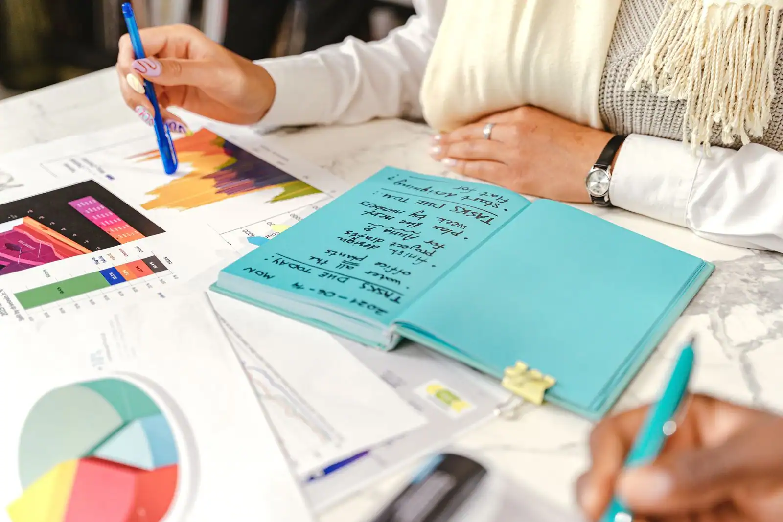 Entrepreneur préparant son plan d'affaires avec des graphiques et un carnet sur un bureau