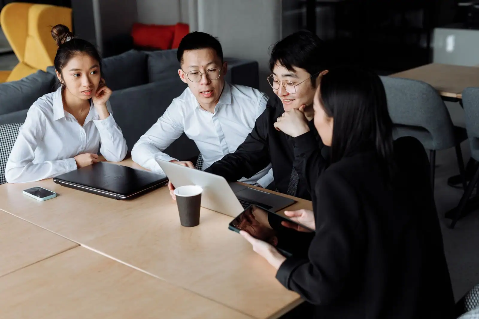 Petite équipe réunie autour d'une table de bureau en pleine discussion de travail