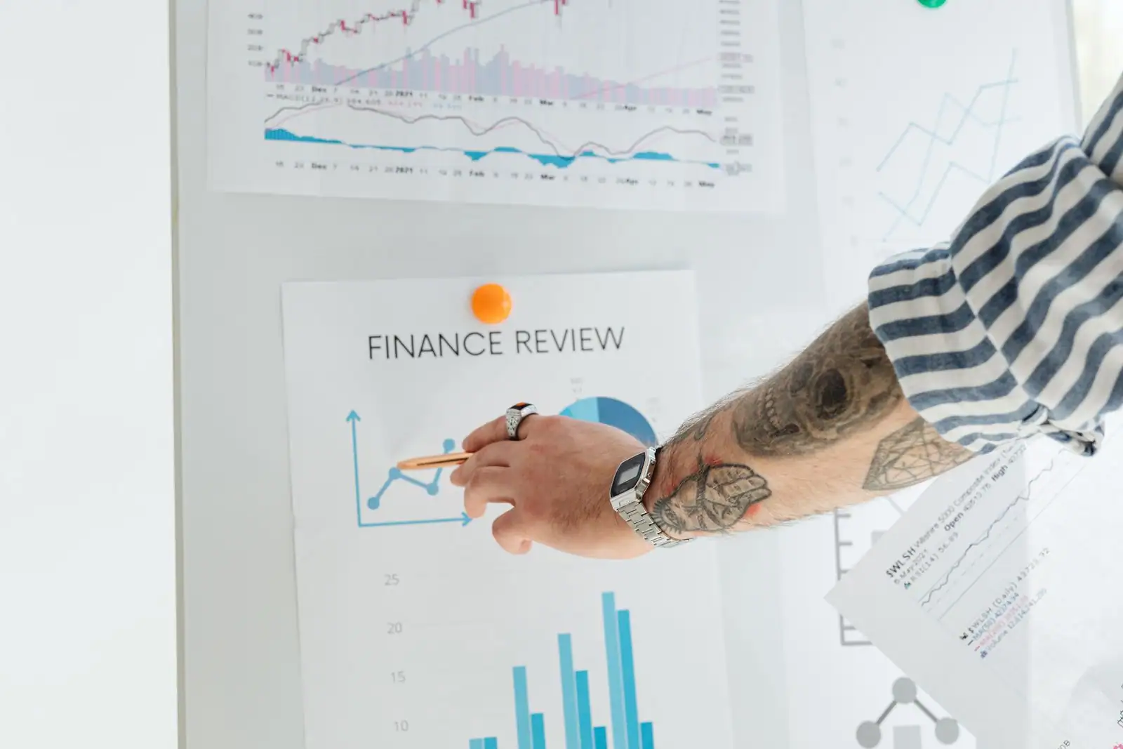Graphiques boursiers et chiffres financiers affichés, désignés à la main lors d'une revue économique