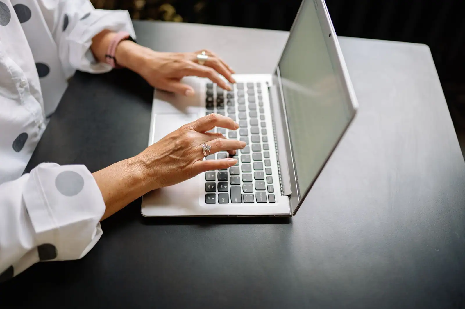 Mains d'une personne saisissant des informations sur le clavier d'un ordinateur portable