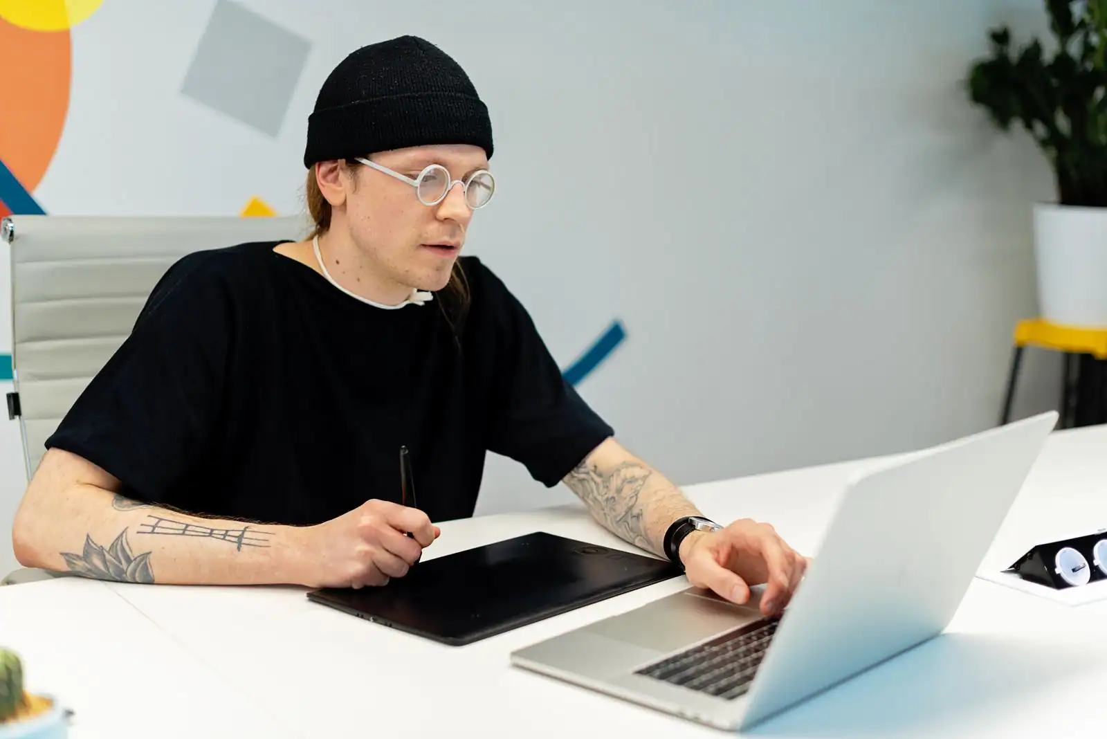Graphiste utilisant une tablette graphique et un ordinateur portable dans un studio de création
