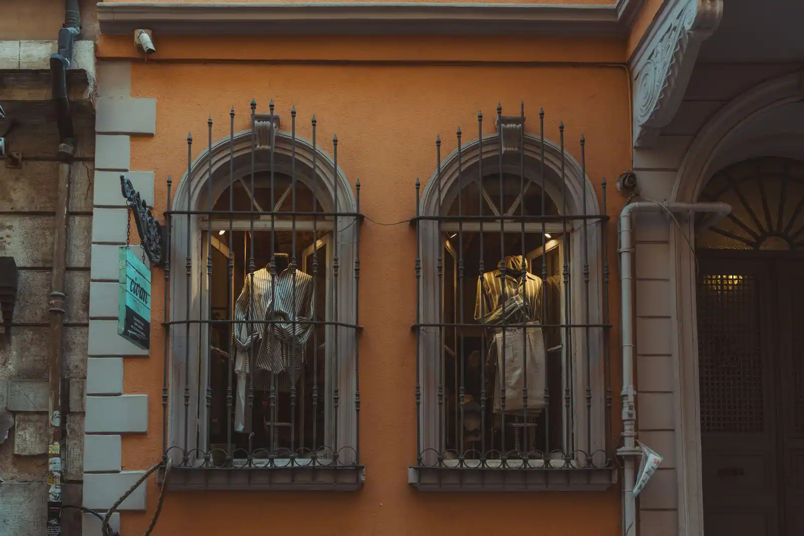 Devanture vitrée d'une boutique de vêtements avec mannequins en vitrine sur une rue ancienne