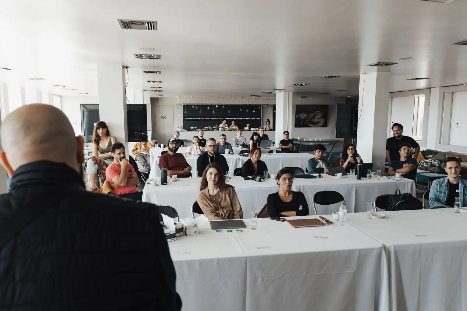 Groupe de professionnels en formation autour d'une table de travail dans une salle lumineuse