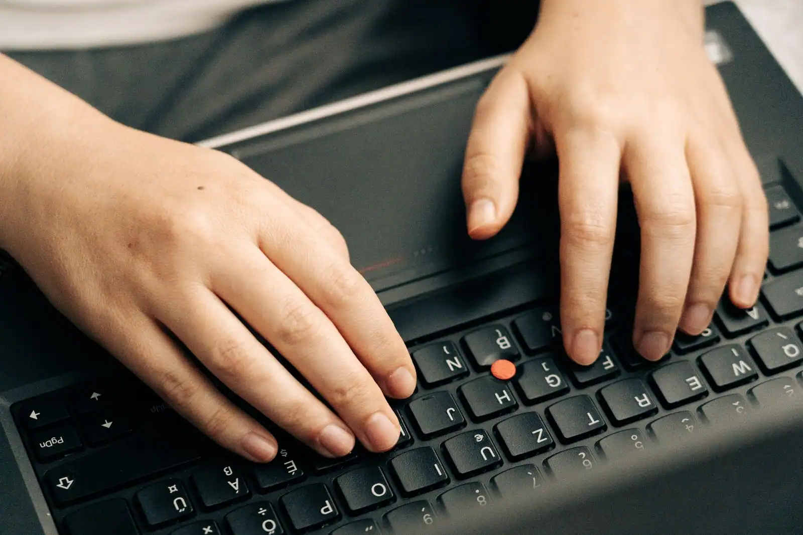 Mains tapant sur le clavier d'un ordinateur portable