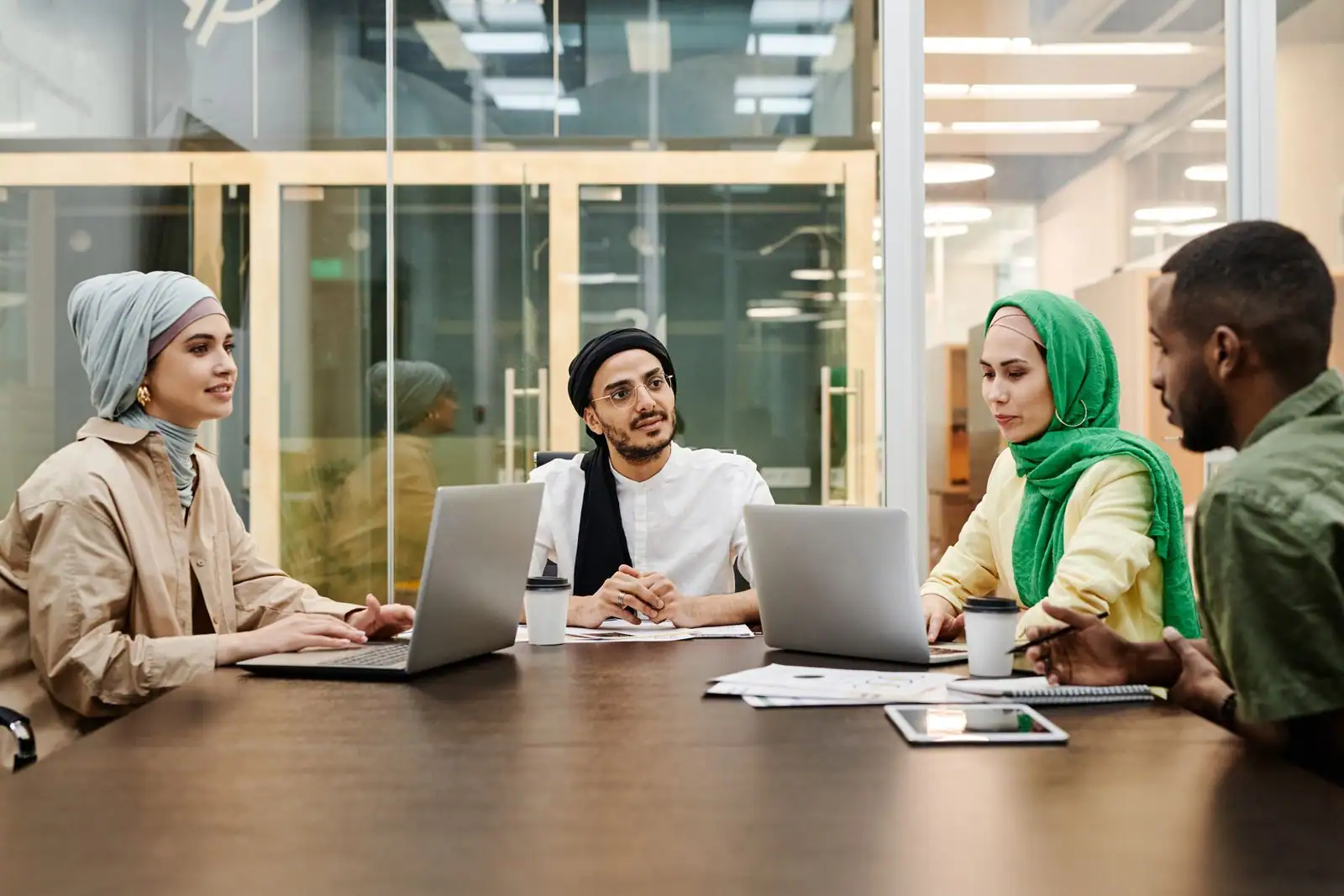 Plusieurs collègues réunis autour d'une table de réunion collaborent sur un projet commun.