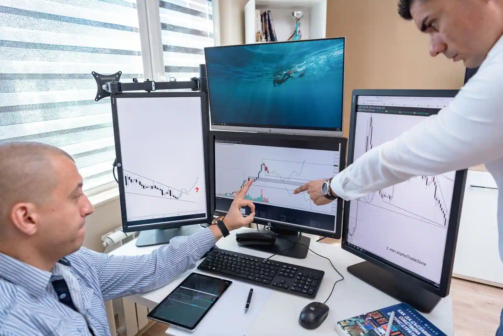 Deux professionnels analysant des graphiques de performance sur des écrans d'ordinateur