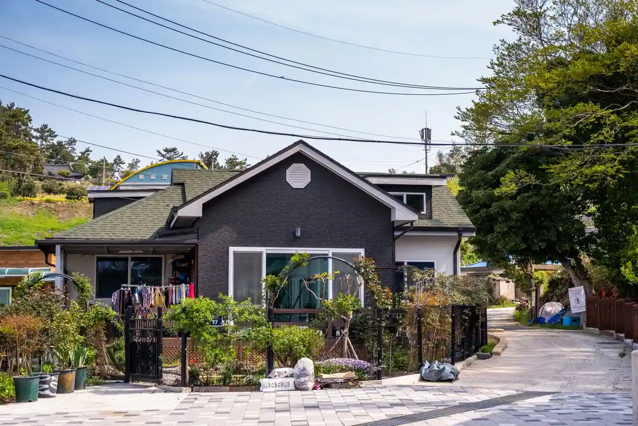 Maison individuelle avec un jardin, vue depuis la rue, illustrant un bien soumis à la taxe foncière.