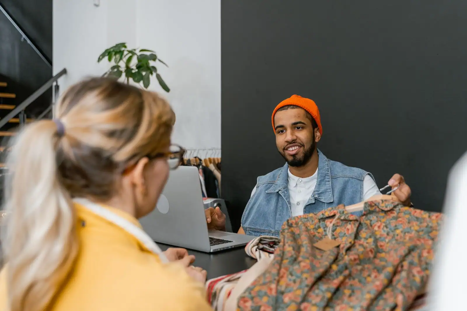 Un vendeur conseille une cliente au cours d'un échange commercial, dans un espace de vente.