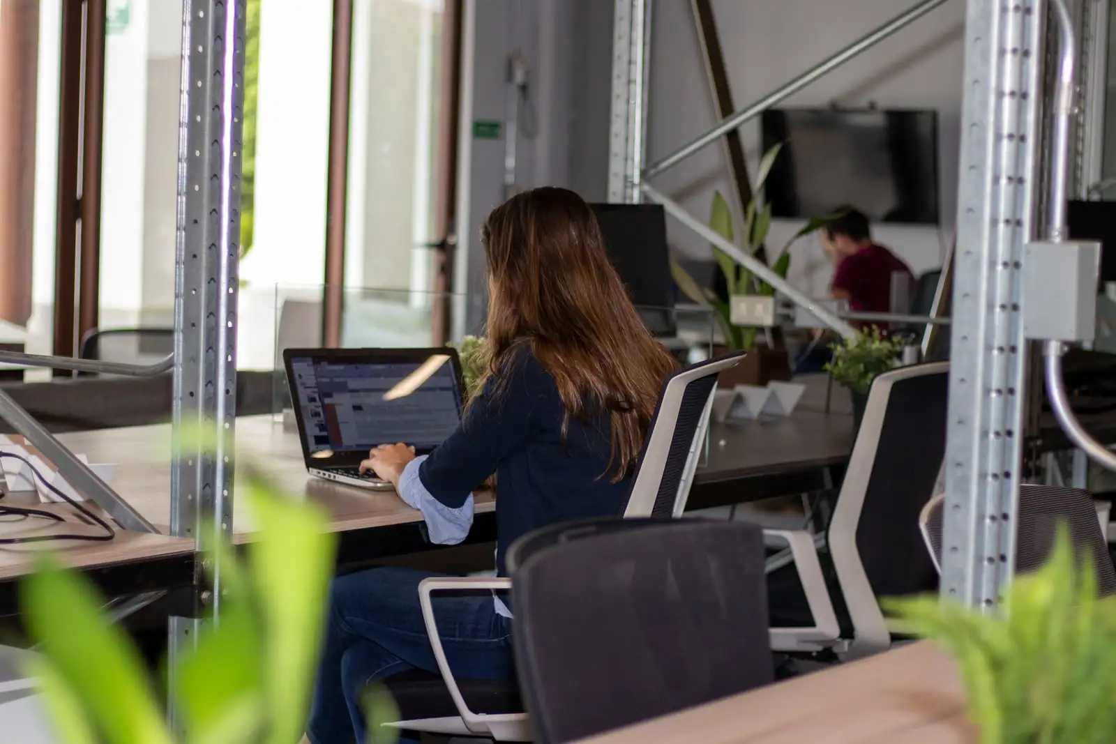 Travailleuse indépendante concentrée devant son ordinateur portable dans un espace de coworking