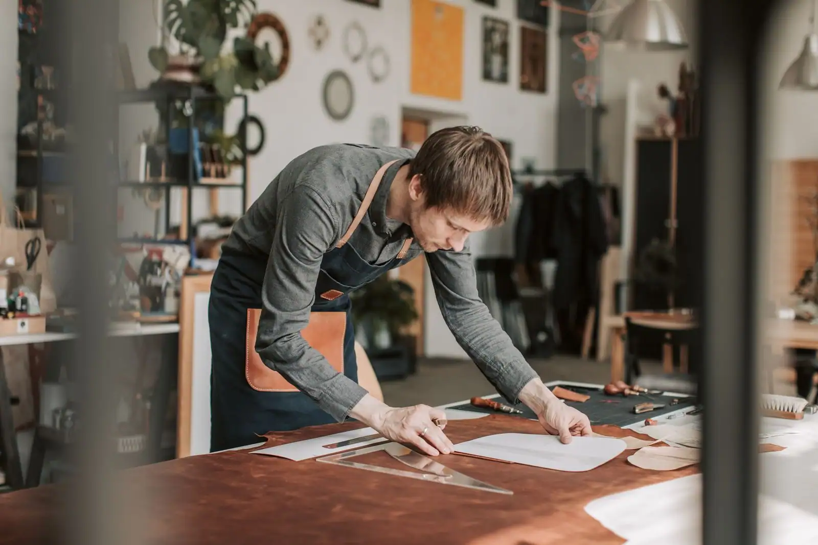 Artisan indépendant travaillant à son établi dans un petit atelier, illustrant l'activité d'un auto-entrepreneur.
