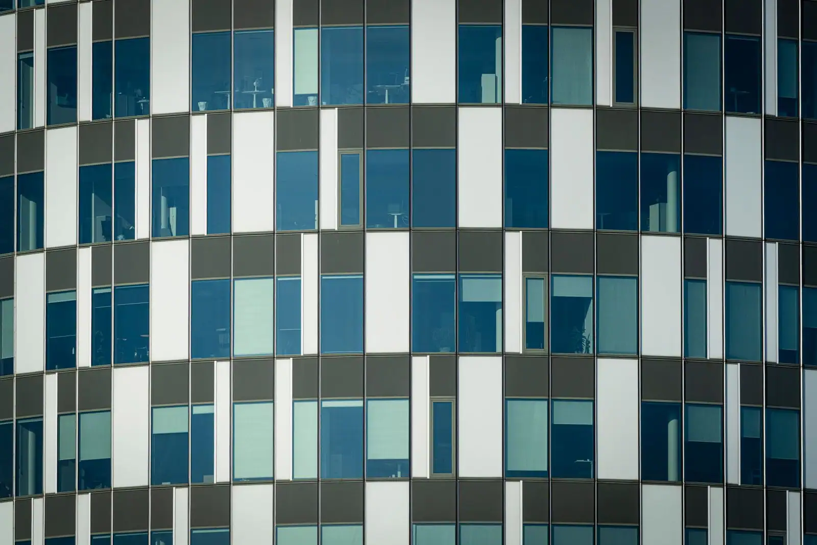 Façade vitrée d'un immeuble moderne, évoquant les matériaux de construction et le secteur du bâtiment