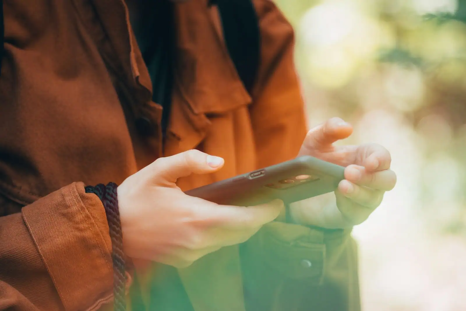 Personne utilisant une application bancaire sur smartphone entourée de plantes vertes, finance responsable