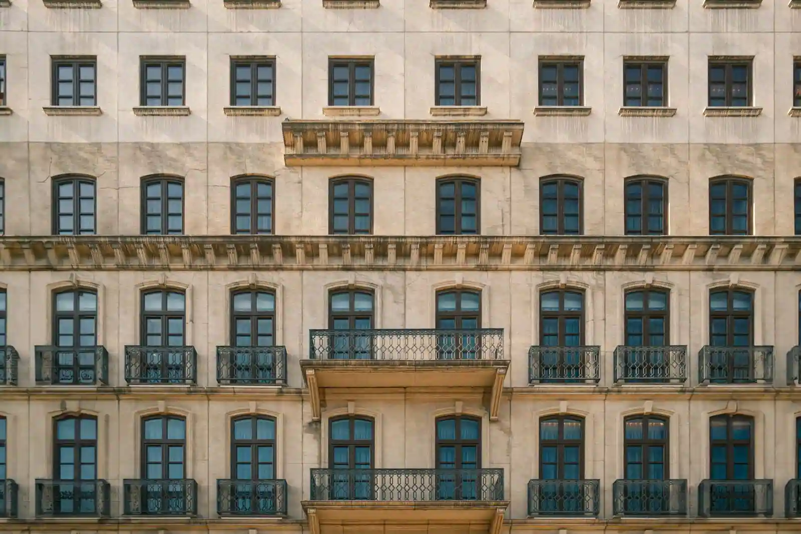 Façade d'un immeuble d'habitation et ses balcons alignés, vue depuis la rue en pleine journée