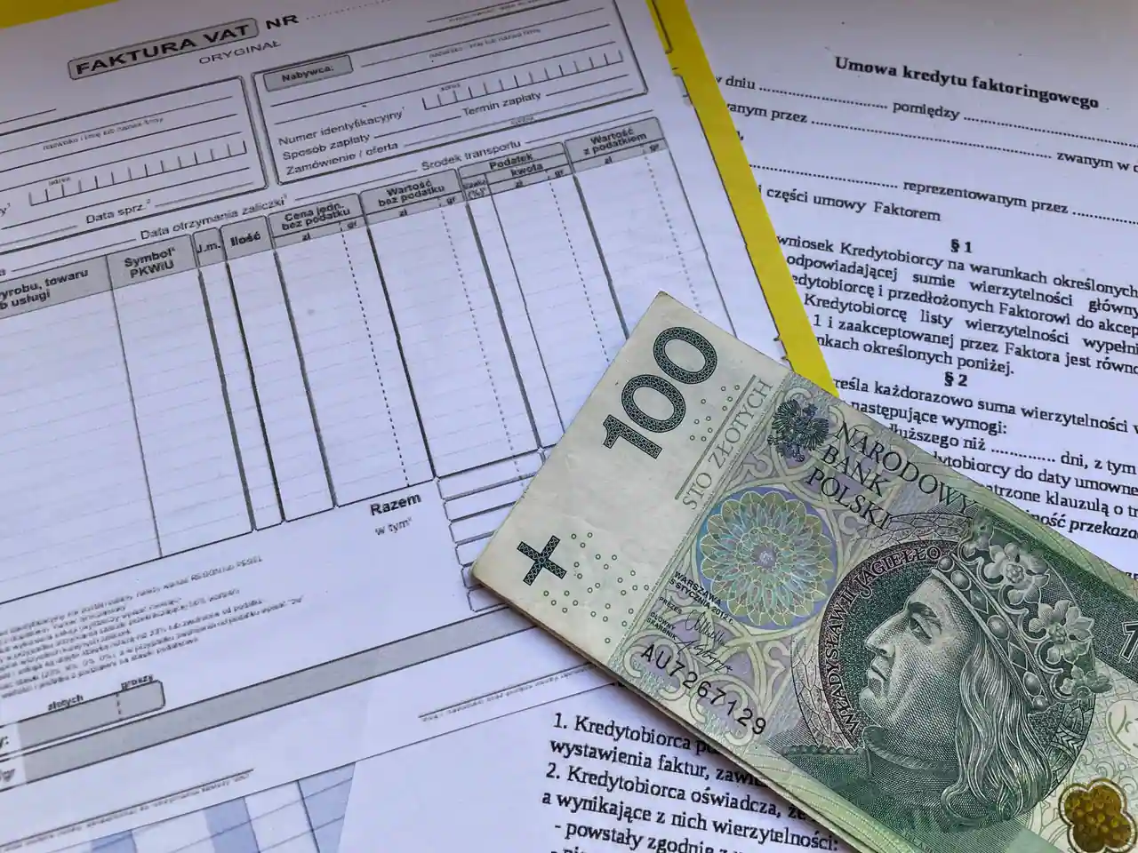 Billet de 100 złotys de la Banque nationale de Pologne posé sur une facture polonaise